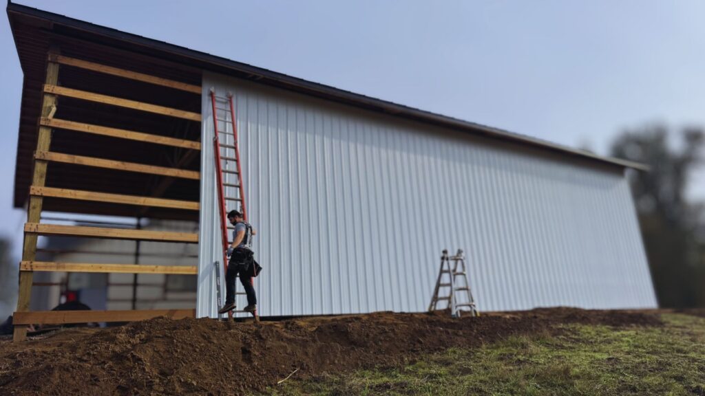 image shows an active pole barn construction project while the metal siding is being added