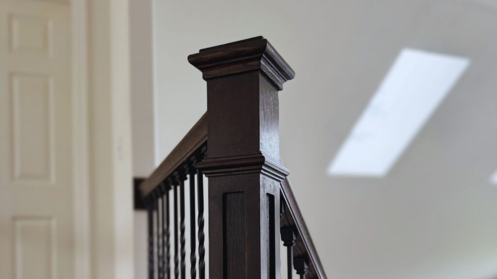 Close up of a newel craftsmen posts and wrought iron spindle railing supports